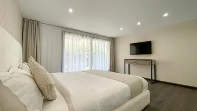 a bedroom with a large white bed and a window at Duplex Zoé - Contemporain et design à Marrakech in Marrakech