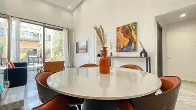a dining room with a white table and chairs at Duplex Zoé - Contemporain et design à Marrakech in Marrakech