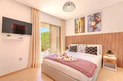 a bedroom with a bed with a tv on the wall at Luxury Apartments Prestigia Pools Golf Fiber Parking in Marrakech