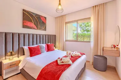 a bedroom with a bed with a teddy bear on it at Luxury Apartments Prestigia Pools Golf Fiber Parking in Marrakech