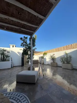 a patio with a white wall and a white couch at Résidence Ghita La terrasse in Marrakech