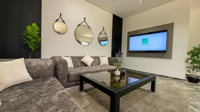 a living room with a couch and a tv at Villa AZUR - piscine chauffée sans vis-à-vis à Marrakech in Marrakech