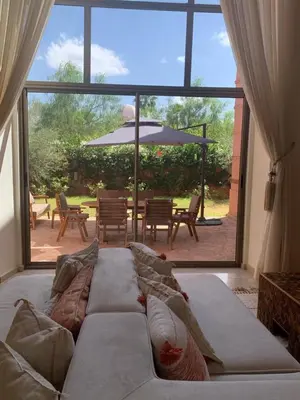 a living room with a couch and a large window at Villa Magnolia - Amelkis Golf in Marrakech