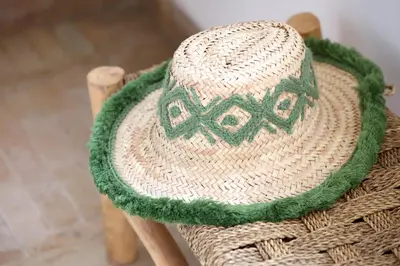 a straw hat sitting on top of a wicker chair at Riad Al Badia in Marrakech