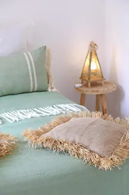 a bed with a pillow and a lamp on a table at Riad Al Badia in Marrakech
