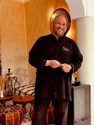 a man wearing a hat standing in a room at Riad Al Badia in Marrakech