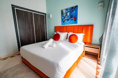 a bedroom with a large bed with orange pillows at Konouz Palace in Marrakech