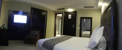 a bedroom with a white bed and a chair at Tempoo Hotel Marrakech City Centre Adults Only in Marrakech