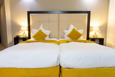 a bedroom with two beds with yellow and white pillows at Tempoo Hotel Marrakech City Centre Adults Only in Marrakech