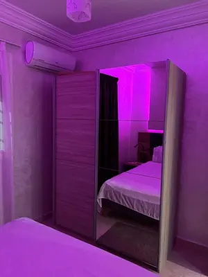 a purple bedroom with a bed and a mirror at Propre appartement à loué pour les familles in Marrakech