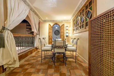 a salon with chairs and a table in a room at Riad Dali in Marrakech