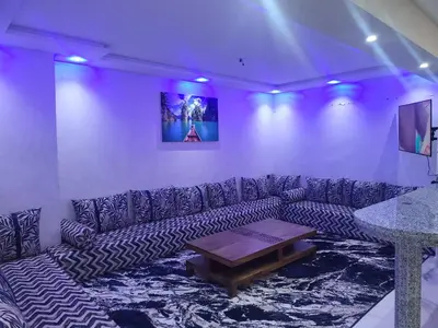 a living room with a couch and a table at Magnifique appartement duplex à 5min de l'aéroport de Marrakech in Marrakech