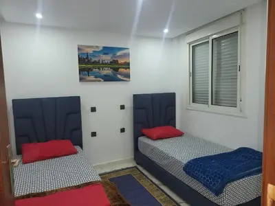 a room with two beds and a window at Magnifique appartement duplex à 5min de l'aéroport de Marrakech in Marrakech