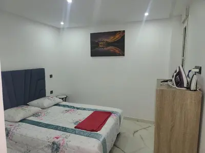 a bedroom with a bed and a picture on the wall at Magnifique appartement duplex à 5min de l'aéroport de Marrakech in Marrakech