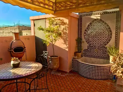 an outdoor bathroom with a tub and a table at Dar Dadès in Marrakech