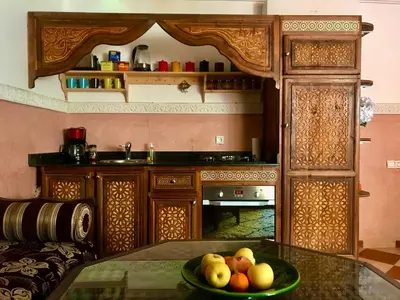 a kitchen with a bowl of fruit on a glass table at Dar Dadès in Marrakech