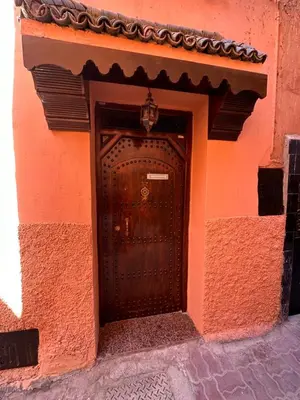 a wooden door in the side of a building at Dar Dadès in Marrakech