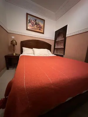 a bedroom with a large bed with a red blanket at Dar Dadès in Marrakech