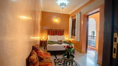 a hotel room with a bed and a balcony at Riad Hadda in Marrakech