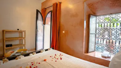 a bedroom with a bed and a window with flowers on it at Riad Hadda in Marrakech