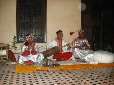 a group of three men sitting on the floor playing instruments at Riad Hadda in Marrakech