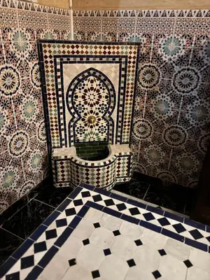 a bathroom with a tile wall with a moroccankish at Riad khoya magnifique in Marrakech