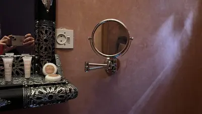 a person taking a picture of a mirror in a bathroom at Riad khoya magnifique in Marrakech