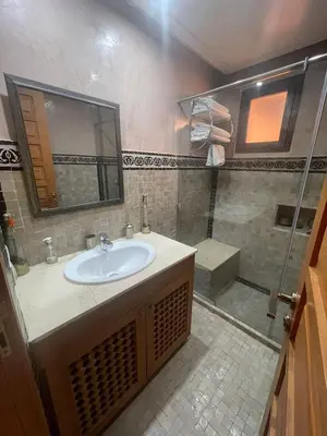 a bathroom with a sink and a shower at Fabuleux appartement, rez de jardin au sein de la palmeraie in Marrakech