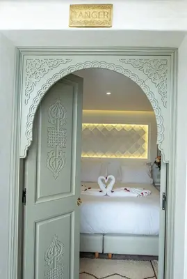 a bedroom with a bed with a door leading into it at Luxe Nomade Marrakech & Spa in Marrakech