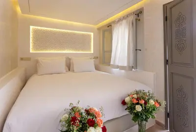 a bedroom with a white bed with flowers on it at Luxe Nomade Marrakech & Spa in Marrakech