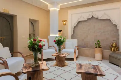 a living room with two tables and a fireplace at Luxe Nomade Marrakech & Spa in Marrakech