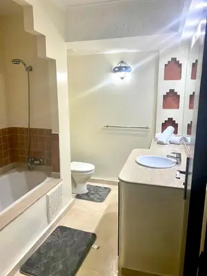 a bathroom with a sink and a tub and a toilet at Charm & Chic Résidence in Marrakech