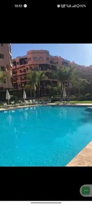 a large blue swimming pool in front of a building at Charm & Chic Résidence in Marrakech
