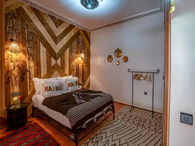 a bedroom with a bed and a wooden ceiling at Riad Dar Nakhla in Marrakech