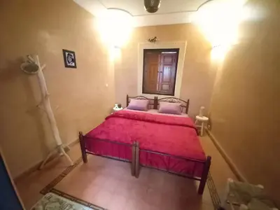 a bedroom with a large red bed with a mirror at Riad Hostel JAD ZIAD in Marrakech