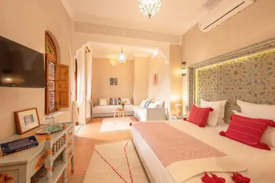 a bedroom with a large bed and a living room at Riad Dar Azal in Marrakech