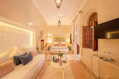 a living room with a white couch and a bed at Riad Dar Azal in Marrakech