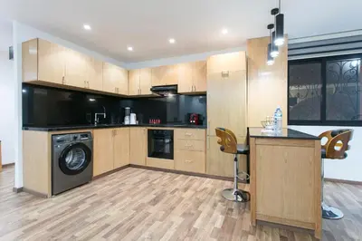 a kitchen with wooden cabinets and a washer and dryer at The Grand Medina Hideaway - Marrakech Centre in Marrakech
