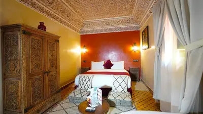 a bedroom with a bed and a dresser in a room at Riad Touhfa Kasbah Marrakech in Marrakech