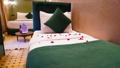 a bedroom with a bed with red rose petals on it at Riad Touhfa Kasbah Marrakech in Marrakech