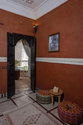 an orange room with an open door and a table at Riad Arabesque in Marrakech
