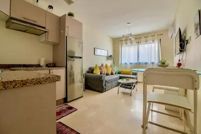 a kitchen and a living room with a refrigerator at Luxurious KING Bed SUITE W/POOL. Well centered. in Marrakech