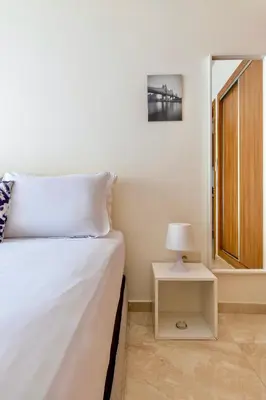 a bedroom with a bed and a nightstand with a lamp at Luxurious KING Bed SUITE W/POOL. Well centered. in Marrakech