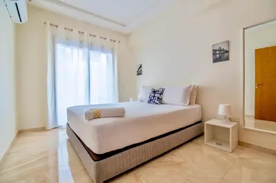 a white bedroom with a large bed and a window at Luxurious KING Bed SUITE W/POOL. Well centered. in Marrakech