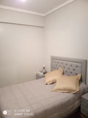 a white bedroom with a bed with two pillows at Chrifia in Marrakech