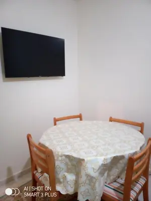 a dining room table with two chairs and a television at Chrifia in Marrakech