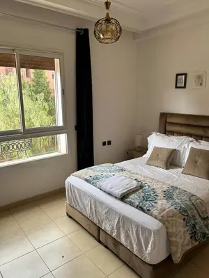 a bedroom with a large bed and a window at belle appartement a Marrakech in Marrakech