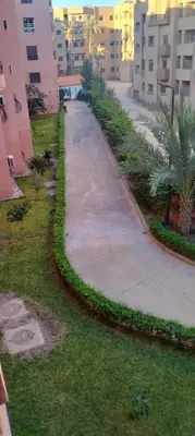 a sidewalk in a city with palm trees and buildings at belle appartement a Marrakech in Marrakech