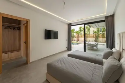 a living room with two beds and a television at Villa Design à Marrakech in Marrakech