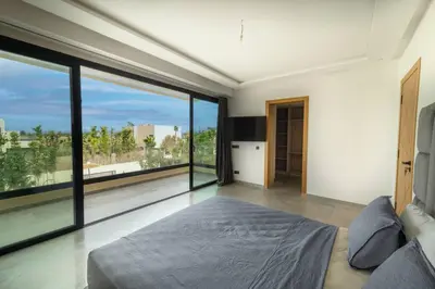 a bedroom with a bed and large glass windows at Villa Design à Marrakech in Marrakech